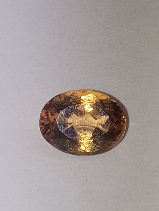 Topaz gemstone Imperial, golden with slightly pink undertones, 7mmx5.5mm oval cut, 1.07ct